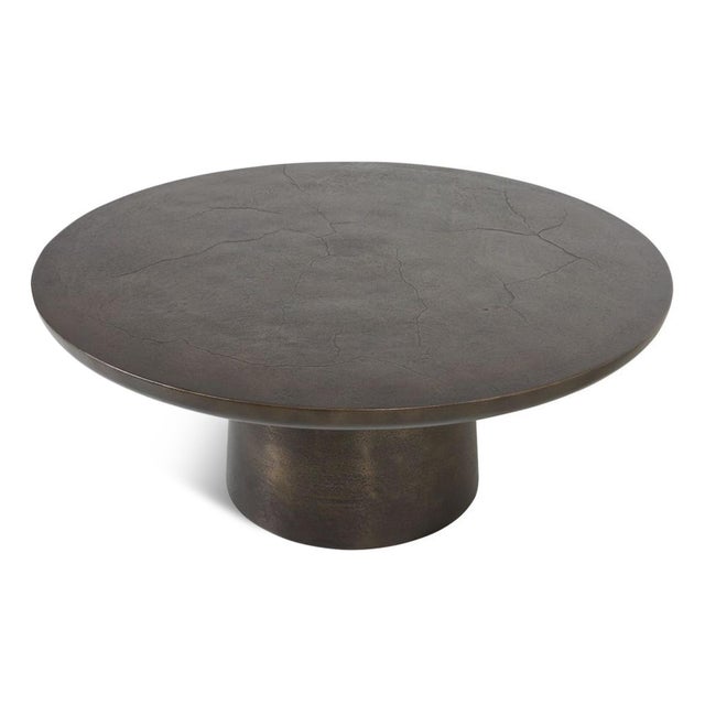Round coffee table crafted from weather-resistant cast aluminum in a rich dark bronze finish that lends warmth and...