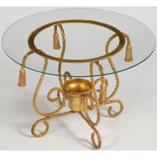 This small round table, or gueridon, has a frame made of gilt iron braided to look like rope.