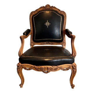 1950s Queen's armchair in carved walnut upholstered with black leather and iron-Gi For Sale