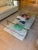 West Elm Mid-Century Art Display Coffee Table (46") featuring a tempered glass top, genuine white marble lower shelf, and...