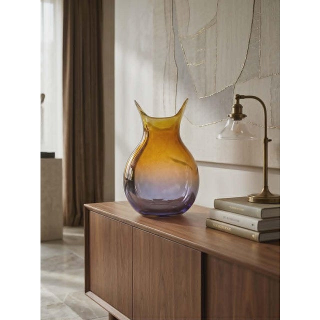 Crafted from iridescent blown glass, this vase features an elegant, flattened shape with a bulbous body, topped by an...