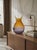 Crafted from iridescent blown glass, this vase features an elegant, flattened shape with a bulbous body, topped by an...