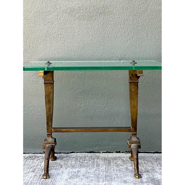 An early 20th century Art Deco side table with a clear rectangular glass top and a sculptural bronze base. The frame has...