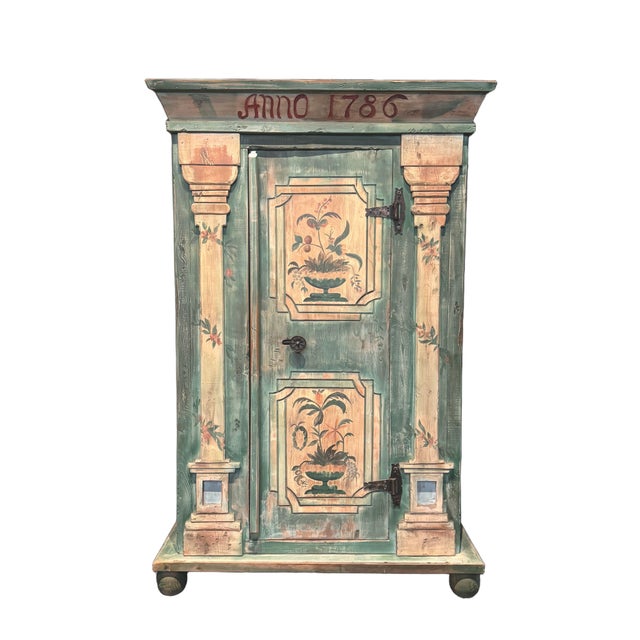A charming custom-made armoire inspired by traditional Italian country furniture, featuring colorful folk-painted...