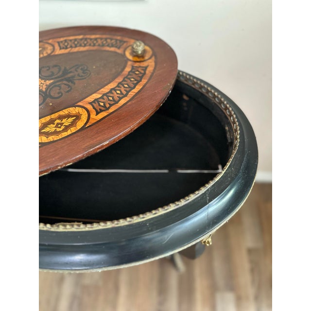 Elegant oval jardinière stand with beautifully inlaid decoration, ebonized legs, gilt metal mounts, and castors. The piece...