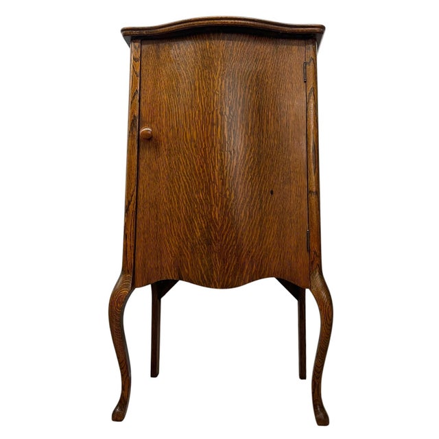This music cabinet features a pronounced grain pattern across the door and case, emphasizing its natural character. The...