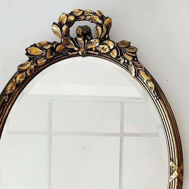 Mid-century oval Baroque mirror with leaf decoration in Hollywood Regency style from the 1960s. This French oval gold...