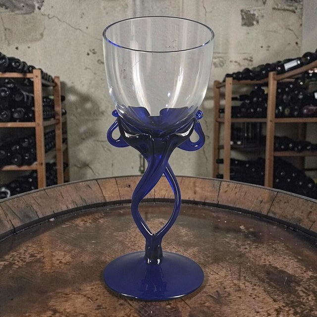 The product is a vintage hand-blown blue stem wine glass attributed to Jozefina Krosno, a contemporary art glass...