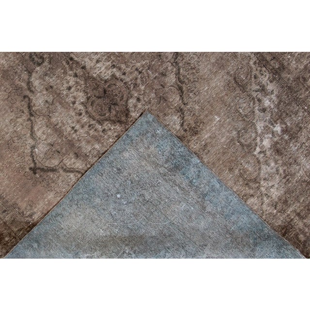 Beautiful hand-knotted vintage wool rug with a brown field. This distressed rug has dark brown accents featuring a...