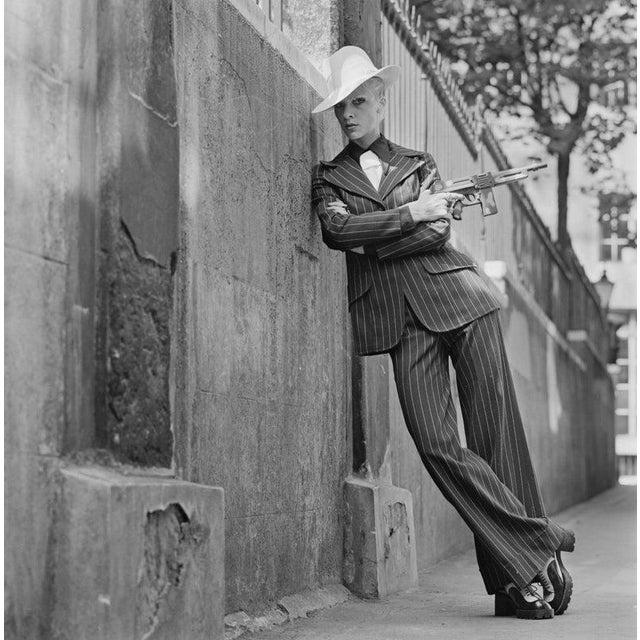Vicki Hodge Goes Gangster English model and actress Vicki Hodge wearing an American gangster-style trouser suit with a toy...