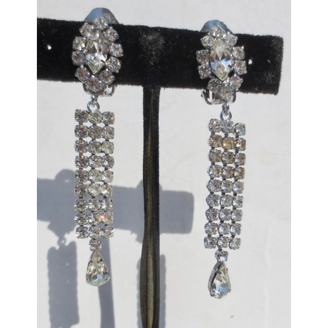 Clip-on dangle rhinestone earrings. dangle design from a cluster clip-on, no markings. The measurements are 70mm by 12mm....
