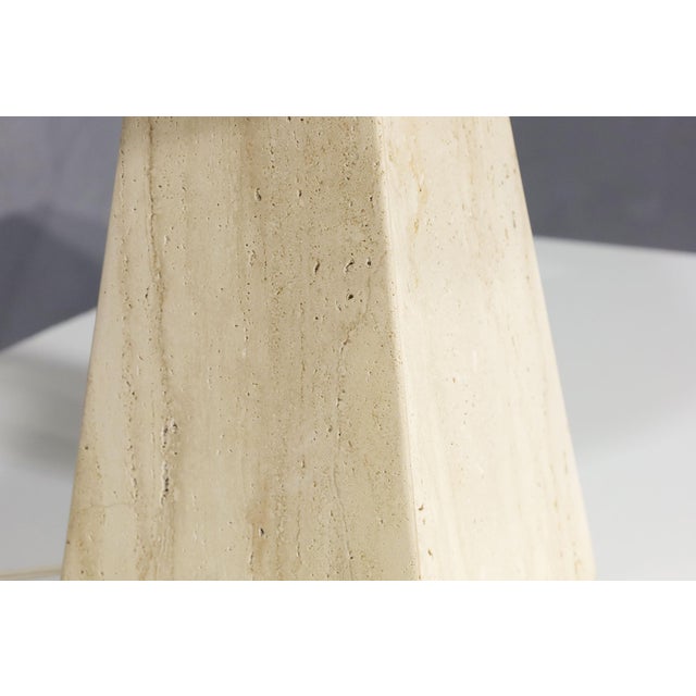 Elevate your interior with the beautifully simple organic travertine table lamp in a pyramid shape, exclusively at...