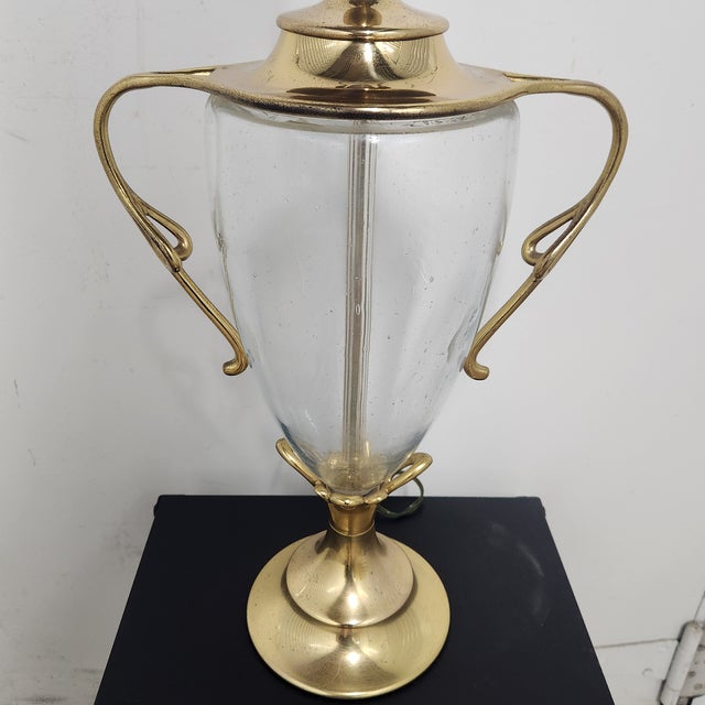 Elegant vintage Chapman urn-form table lamp crafted in warm brass with a clear seeded glass body. The sculptural brass...