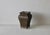 Vintage footed brass planter featuring an aged dark patina, an embossed leaf and fluted panel design, and a pierced square...