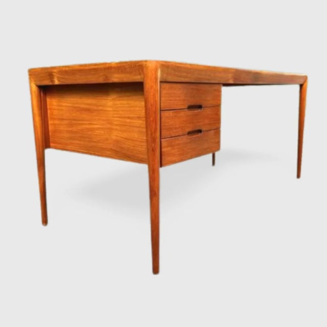 50 Hare teak desk with three drawers. The desk is in excellent condition. This piece is attributed to the mentioned...