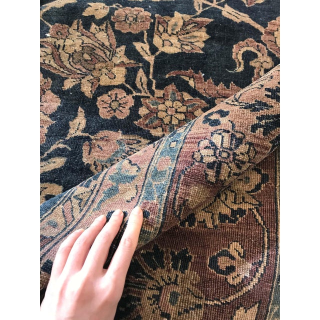 An early 20th century Persian Tabriz antique carpet, the midnight blue field with an allover trellis of palmettes,...