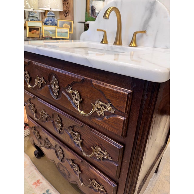 This 19th century French chest of drawers with ornate brass pulls feels fresh and functional again with addition of...