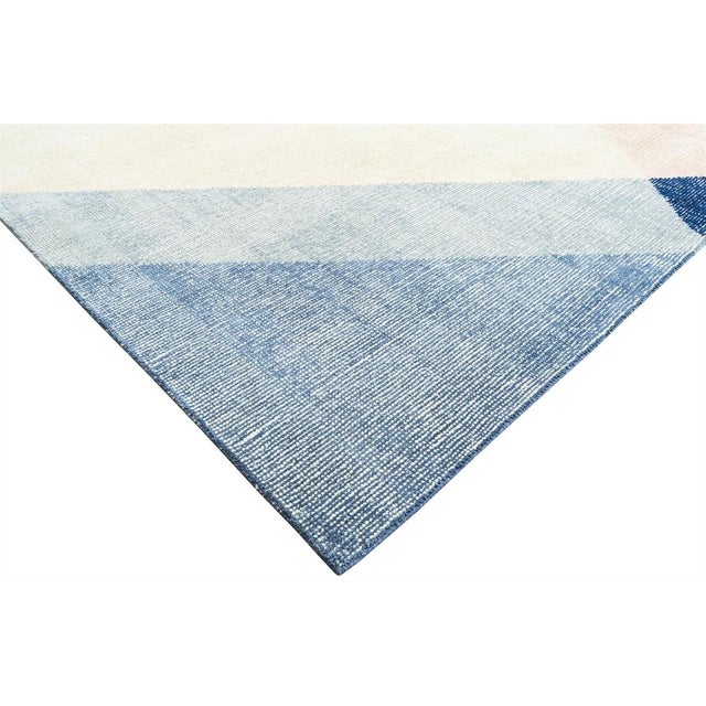 This loom knotted cotton & Wool Rug features a geometric pattern with multi colors, creating an eye-catching example that...