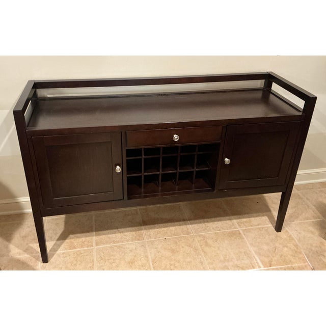 Bring streamlined functionality and crisp geometry to your dining or entertaining space with this transitional wine buffet...