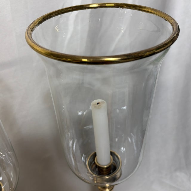Elegant pair of vintage Decorative Crafts, Inc. brass and glass hurricane candle holders. Style 3270. Each features a...