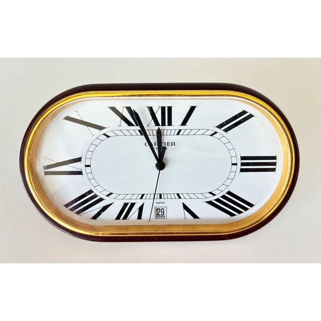 Cartier Paris “Accordion” Desk Clock with Date, Burgundy Enamel and Roman Numeral Dial, circa 1980. A distinctive and...