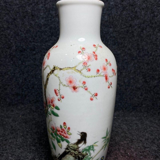 This elegant vintage porcelain vase features a classic bottle form with a tall, slender neck. The body is finely hand-...