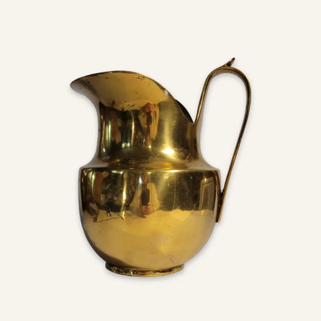 This heavy guage brass ewer is likely 19th century and English. It was intended to carry water, and has a reinforced...