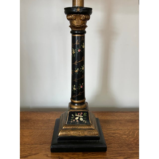 Charming black and gold Neoclassical style column lamp with hand-painted floral motif surround. The light bulb sits above...