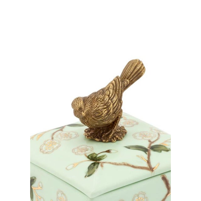 This charming mint green ceramic box features delicate floral patterns and a sweet golden bird perched on top. Perfect for...