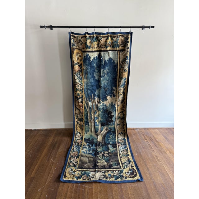 A French antique tapestry featuring elaborate ornamentation and finely woven details. Its rich design and graceful patina...