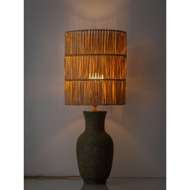 A sculptural mid-century ceramic table lamp by Hubert Guy of Accolay, featuring a mottled light blue and brown volcanic...