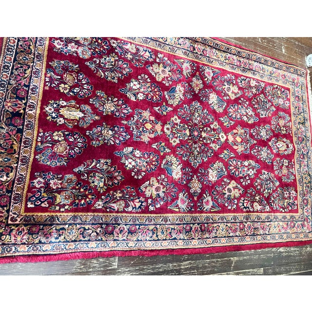 This elegant antique Persian Sarouk rug, measuring approximately 3'3" x 5'3" and dating to around 1930, is a beautiful...