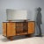 Vintage Italian-made sideboard with walnut veneer, hinged doors, open compartments and drawers, and a mirrored top. This...