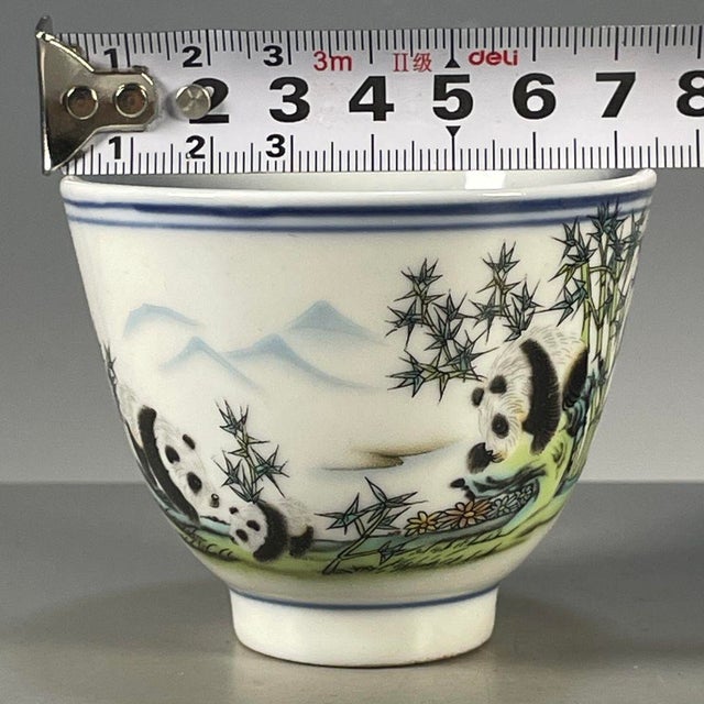 A charming Chinese porcelain tea cup. The white ground is hand-painted in vibrant Famille Rose enamels with a playful...