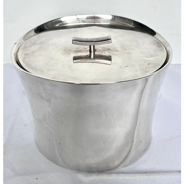 Made in Italy. Mid-century style high gloss stainless steel ice bucket. Oval with concave sides and curved bamboo handle....