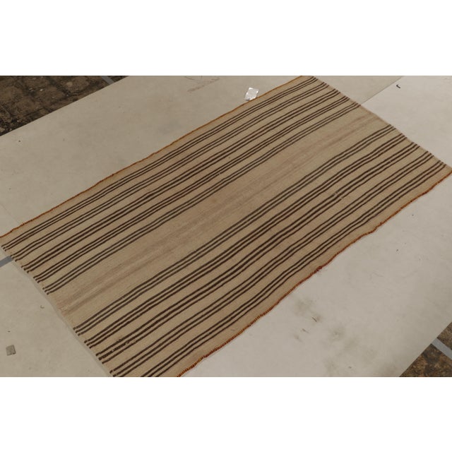 Handwoven in wool connoting mid-century panel weaving styles, a 5x8 vintage kilim from our newly curated flatweaves....