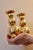 Made in Sweden. A pair of Swedish brass candle holders shaped like spheres and resting on three balled feet by GUSUM dated...