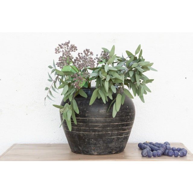 Featuring a beautifully weathered gray finish, this large vintage pottery vase stands out with its rounded silhouette and...