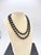 A refined continuous strand of polished black onyx beads, displaying the high-gloss finish characteristic of quality...