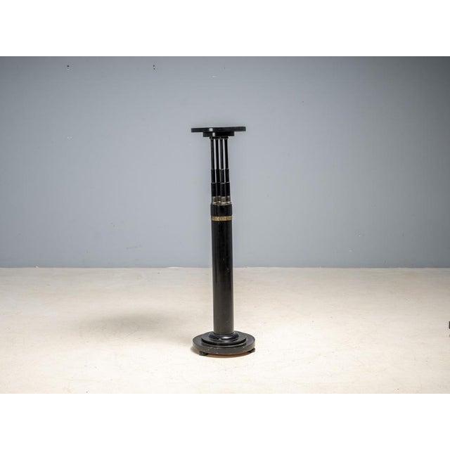 Elegant black lacquered pedestal or display stand from the 20th century, featuring a refined architectural composition and...