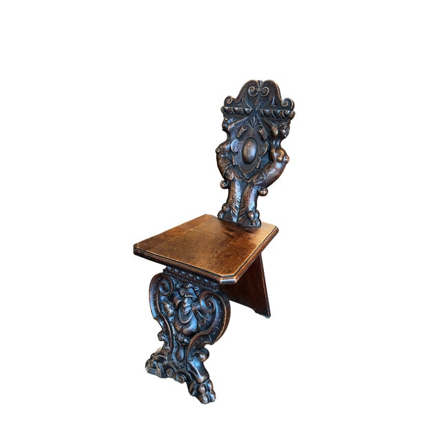 An imposing pair of expertly hand-carved late 19th-century Italian hall chairs. These chairs, known as sgabelli, exemplify...