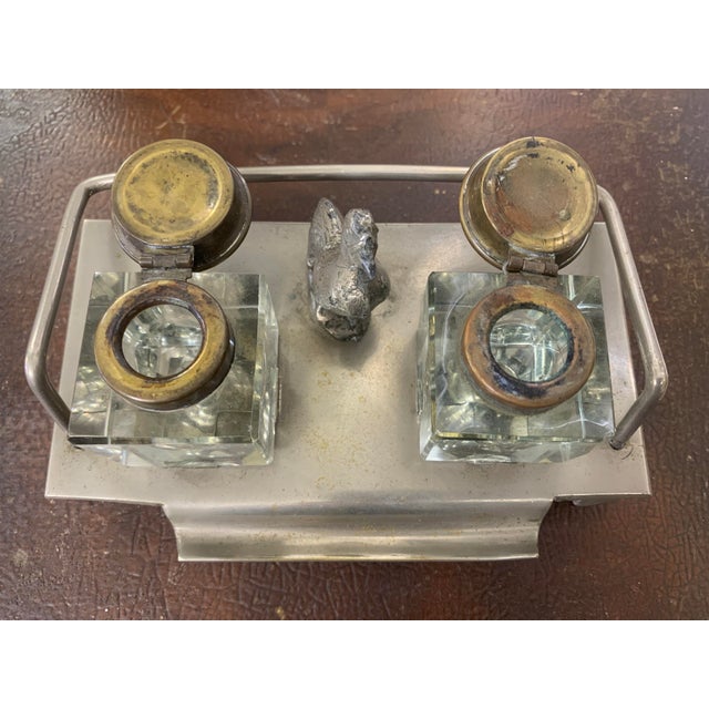 Charming antique double inkwell desk set featuring two square crystal ink bottles with original metal lids, mounted on a...