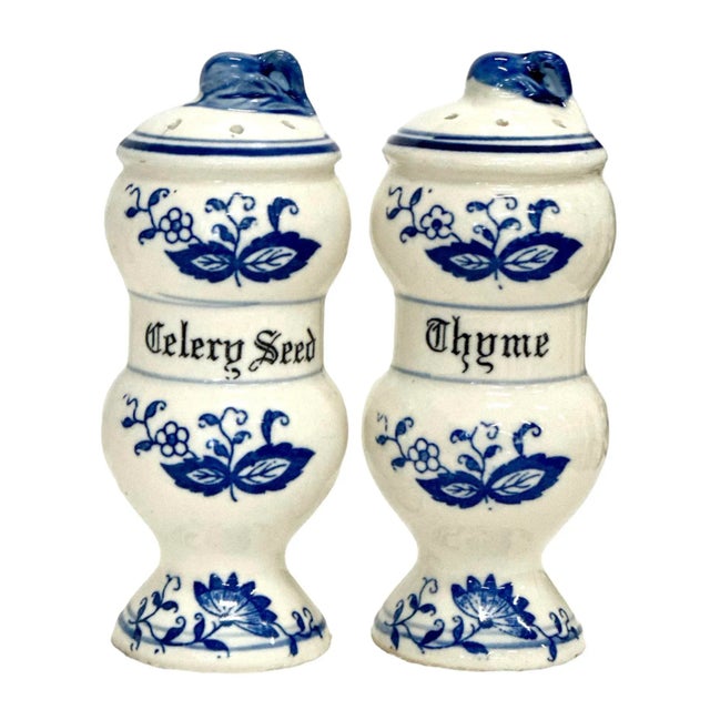 1950s Blue Onion china spice set includes 11 shakers and a 3 tier wooden spice rack with 2 pegs at bottom. There are 11...