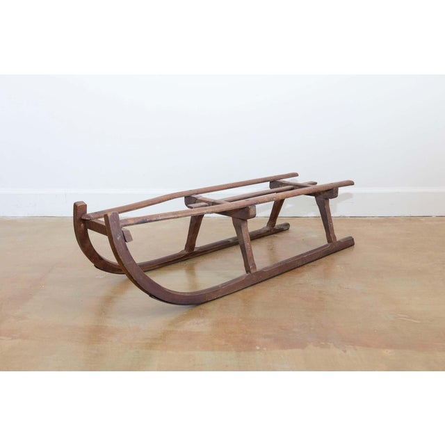 A French rustic wooden sled from the 19th century with curving extremities. Charming our eyes with its rustic appearance...