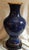 A Chinese Cloisonné Vase from the 20th century featuring blues and gold floral design on blue enamel. The rim and base are...