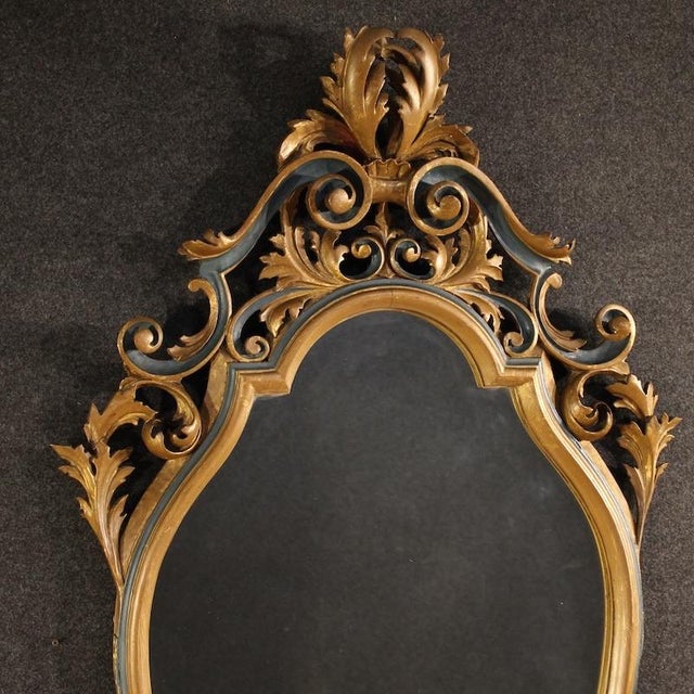 Great mid-20th-century Italian mirror. A large and striking furniture of carved, lacquered, and gilded wood (bronze...