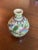 A Persian ceramic vase from the Qajar dynasty. Brightly painted with flora and geometric patterns on a cream colored...