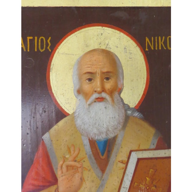 An unusual painted Russian icon of St. Nicoli on wood. It is unusual in that on the rear are writings in five different...