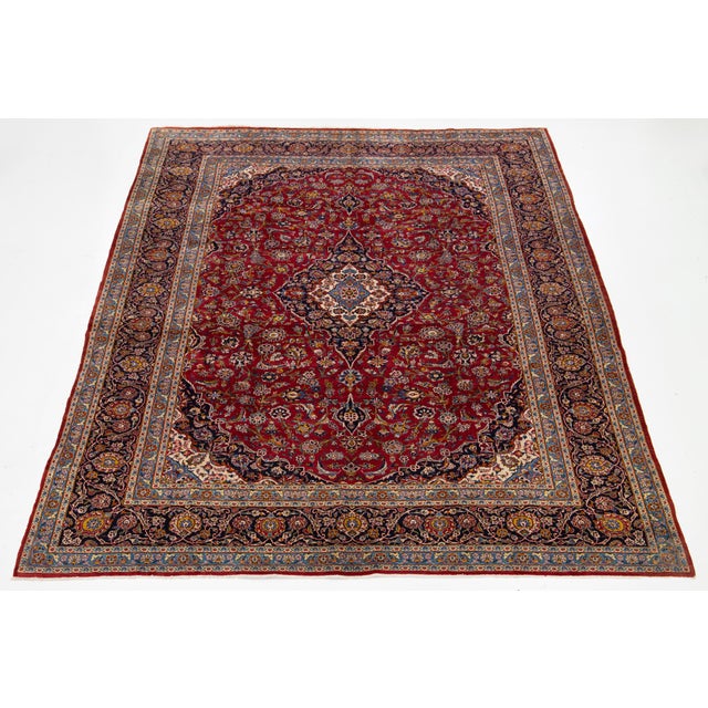 This vintage red Kashan Persian wool rug showcases a stunning medallion design adorned with vibrant multicolor accents....