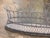 A generously sized oval wire basket with a tall arched wire gallery rising from a coiled wire rim. The body is worked in...